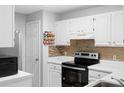 Kitchen offers white cabinets, tile backsplash, and updated appliances at 1950 Summer Club Dr # 200, Oviedo, FL 32765