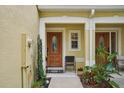 Inviting entryway with a decorative glass front door, charming plants and a cozy chair at 1967 Beacon Bay Ct, Apopka, FL 32712