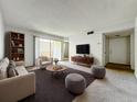 Bright living room featuring neutral tones, a large window, and modern furnishings at 200 St Andrews Blvd # 911, Winter Park, FL 32792