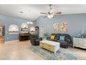 Cozy living room with tile floors, a ceiling fan, a modern rug, and colorful decor at 2042 Hayfield Way, Apopka, FL 32712