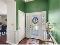 Welcoming entryway with decorative glass door, accent walls, and hardwood flooring at 2220 Derbyshire Rd, Maitland, FL 32751