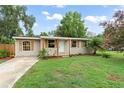 Charming single-story home with a well-kept lawn, complemented by lush landscaping and a welcoming front entrance at 247 Toms Rd, Debary, FL 32713