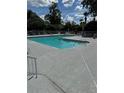 A community swimming pool surrounded by lounge chairs and lush greenery offers a relaxing outdoor space at 2592 Grassy Point Dr # 306, Lake Mary, FL 32746