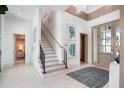 Bright foyer featuring modern art, a staircase with sleek railings, and elegant tile flooring at 4007 Grande Brick Loop # 13, Orlando, FL 32837
