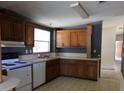 Traditional kitchen featuring wood cabinets, white appliances, and a window over the sink at 41 Sunset Cir, Lake Alfred, FL 33850