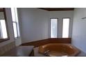 Bathroom with a corner soaking tub and natural light from the three small vertical windows at 41 Sunset Cir, Lake Alfred, FL 33850