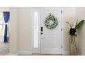 Bright entryway featuring a classic white door adorned with a decorative wreath at 412 Mallard Way, Kissimmee, FL 34759
