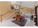Spacious living area featuring a billiard table, staircase, and sliding doors to the backyard at 425 Sterling Lake Dr, Ocoee, FL 34761