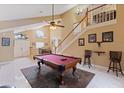 Bright living area showcasing a billiard table, tall ceilings, staircase and ample natural light at 425 Sterling Lake Dr, Ocoee, FL 34761