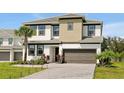Charming two-story home showcasing lush landscaping, neutral color scheme, and a two-car garage at 4429 Ganesha Loop, Kissimmee, FL 34746