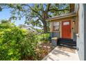 Exterior view of a home's red front door and a lush, green garden at 524 S Lakeview Ave, Winter Garden, FL 34787
