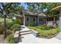 Quaint blue home with a red door, green landscaping, and a walkway at 524 S Lakeview Ave, Winter Garden, FL 34787