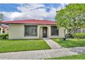 Charming single-story home with a red tile roof, lush lawn, and mature shade tree at 557 Hunter Cir, Kissimmee, FL 34758