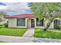 Charming single-story home with a red tile roof, lush lawn, and mature shade tree at 557 Hunter Cir, Kissimmee, FL 34758