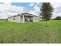 The back of this lovely home includes a grassy yard and partially covered patio area at 5909 Cliffbow Loop, Leesburg, FL 34748