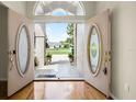 Elegant entryway features glass double doors and transom window with views of the front yard at 707 Heritage Ne Dr, Winter Haven, FL 33881