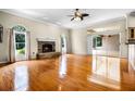Spacious living room with hardwood floors, stone fireplace, and sliding glass doors to the lanai at 707 Heritage Ne Dr, Winter Haven, FL 33881