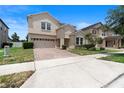 Well-maintained two-story home featuring a brick driveway, landscaping, and a two-car garage at 7409 Fairgrove Ave, Windermere, FL 34786
