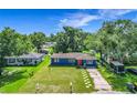 Aerial view of blue home with green lawn, red door and mature trees, showcasing its curb appeal at 91 High St, Winter Haven, FL 33880