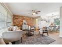 Cozy living room featuring a brick accent wall, contemporary furnishings, and natural light at 941 Grey Oak Ct, Orlando, FL 32809