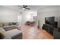 Open-concept living room and dining area with terra cotta tile flooring and contemporary furnishings at 116 E Lauren Ct, Fern Park, FL 32730