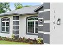 Close up of home's exterior, showcasing the house number, decorative wall lamp and freshly planted flowerbeds at 1161 Roxboro Rd, Longwood, FL 32750