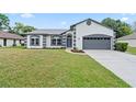 Charming single-story home with a manicured lawn, neutral tones, and attached two-car garage at 1161 Roxboro Rd, Longwood, FL 32750