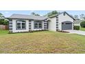 Single-story home with a well-manicured lawn, gray roof, and an attached garage in a suburban setting at 1161 Roxboro Rd, Longwood, FL 32750