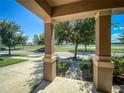 Inviting front porch with decorative columns and a view of the pond and street at 12795 Bosworth Ave, Windermere, FL 34786