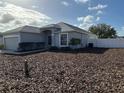 Well maintained lawn surrounds the exterior of this single-Gathering home with white fencing at 1354 Knollwood Dr, Davenport, FL 33837
