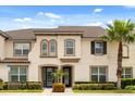 Charming townhouse with a stucco exterior, neat landscaping, and a mature palm tree at 1592 Carey Palm Cir, Kissimmee, FL 34747