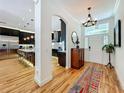 Open-concept view of the foyer featuring hardwood floors, lighting and transition to kitchen and living spaces at 1640 Mayfield Ave, Winter Park, FL 32789