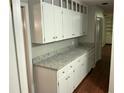 Butler pantry with counterspace, ample white cabinet storage, and hardwood flooring at 17836 Palm St, Umatilla, FL 32784