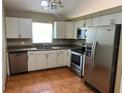 Kitchen features stainless steel appliances, tile floor, a window and lots of cabinet storage at 1809 Elm Ridge Ct, Orlando, FL 32808