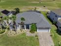 An aerial view shows the attractive home with a screened in patio and golf course behind the property at 204 Birkdale St, Davenport, FL 33897