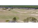 An aerial view captures the expansive golf course and the rear of nearby homes, all set against a backdrop of trees at 204 Birkdale St, Davenport, FL 33897