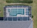 Aerial shot showcasing a sparkling screened-in pool and hot tub, surrounded by lounge chairs for relaxation at 204 Birkdale St, Davenport, FL 33897
