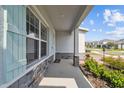Charming covered front porch with stone accents, a welcoming entrance, and meticulously maintained landscaping at 2056 Airedale Way, Lake Alfred, FL 33850