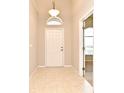 Inviting tiled foyer with high ceilings, transom window above door, and natural light at 2131 Kaylas Ct, Orlando, FL 32817