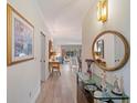 Bright entryway featuring wood-look flooring, decorative mirror, console table, and a glimpse into the living areas at 235 S Shadowbay Blvd, Longwood, FL 32779