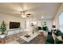 Stylish living room features modern decor, a ceiling fan, and an open concept design to the kitchen and dining area at 3354 Summerdale Way, Kissimmee, FL 34746