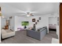 Bright living room with gray laminate flooring, featuring a ceiling fan and plenty of space for entertaining at 340 Pheasant Dr, Haines City, FL 33844