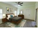 Modern bedroom showcases a ceiling fan, framed art, and dresser with a round mirror at 340 Sorrento Rd, Kissimmee, FL 34759