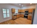 Bright kitchen features hardwood floors, stainless steel appliances and light-colored countertops at 340 Sorrento Rd, Kissimmee, FL 34759