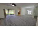 Spacious living room featuring neutral walls, carpeted flooring, and sliding doors leading to a screened patio at 340 Sorrento Rd, Kissimmee, FL 34759