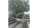 Wrought iron gate to Placid Lake Townhomes with lush landscaping and mature trees at 454 Wilton Cir, Sanford, FL 32773