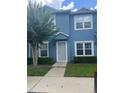 Two-story blue townhome with neatly trimmed hedges and green lawn at 454 Wilton Cir, Sanford, FL 32773