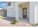 Inviting home entrance featuring a classic front door, spacious porch, and lush landscaping at 9027 Coral Cape St, Kissimmee, FL 34747