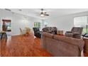 Spacious living room featuring wood floors, ceiling fan, and comfortable furniture at 909 Hendon Place, Kissimmee, FL 34758