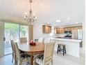 Inviting dining area with chandelier, and open flow to the bright kitchen with stainless steel appliances at 1008 Jackson St, The Villages, FL 32162